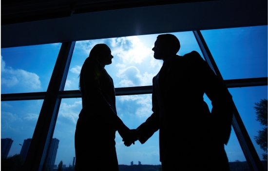 Divorce Attorneys at Davis Law Firm in Seattle Two people shaking hands in front of a window. Divorce attorneys in Seattle can help you find resolve quickly.
